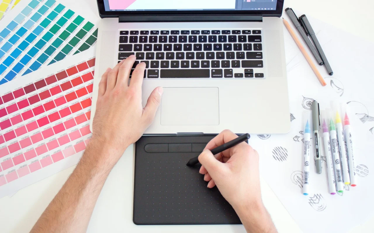 Graphic designer working on a laptop with colour swatches