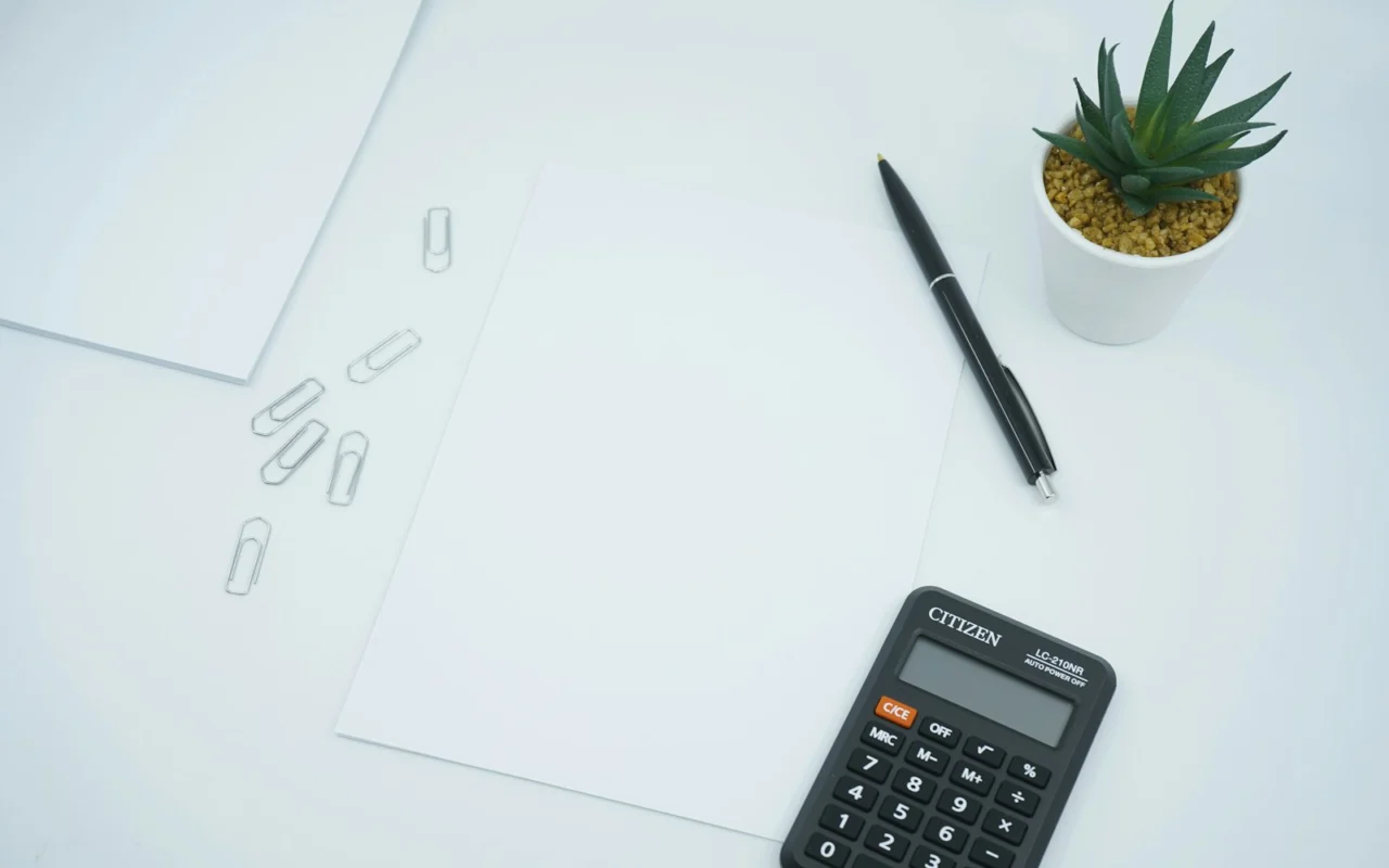 Blank planning sheet with a pen and calculator on a desk